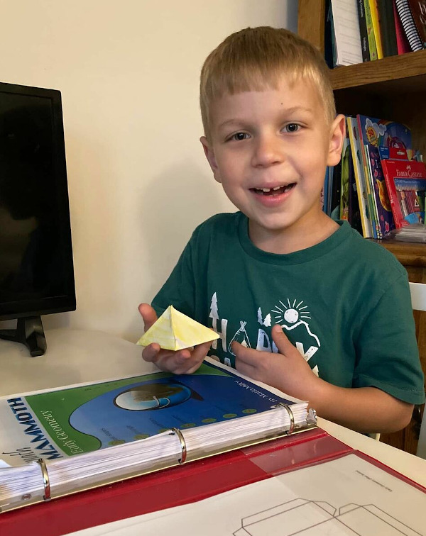 boy holding a pyramid made of paper