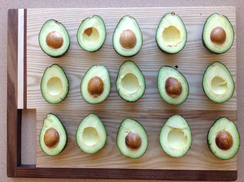 15 avocado halves, some with pits, some without